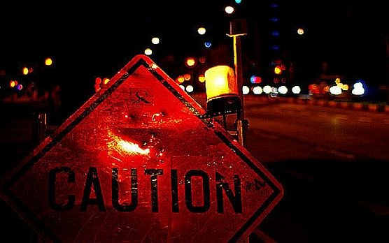 a caution road sign with a flashing light